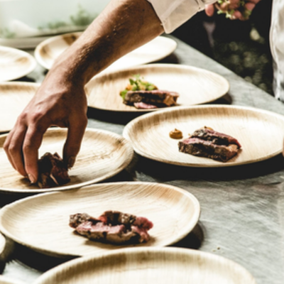 Palmunlehdistä valmistettuja lautasia, joille asetellaan ruokaa