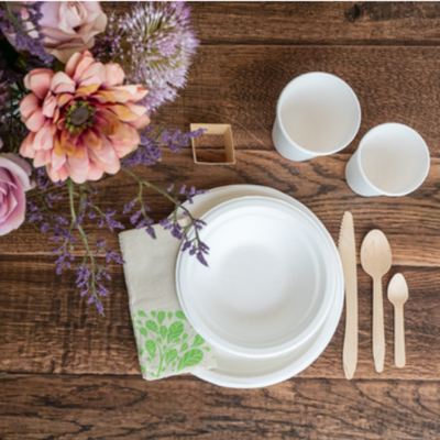 Paperilautaset aseteltuna kattaukseen kukkien kera